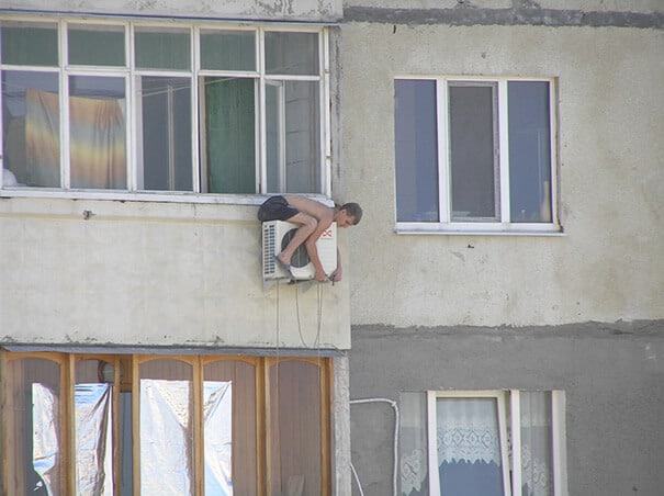 Un homme répare une climatisation au-dessus du vide