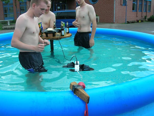 Des jeunes dans une piscine avec une prise électrique