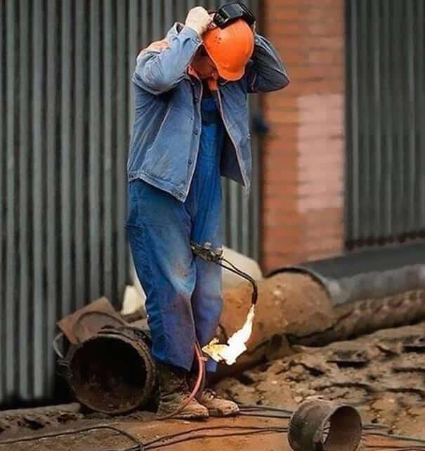 Un homme resserre son casque avec un chalumeau