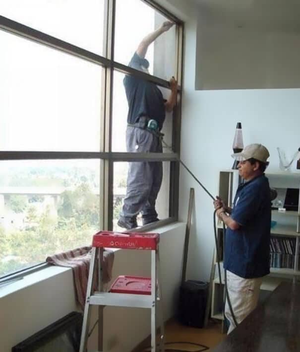 Un nettoyeur de vitre qui fait confiance à son collègue