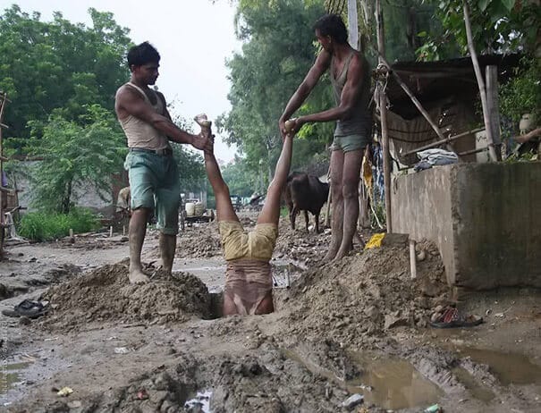 Deux hommes tiennent par les pieds un autre homme