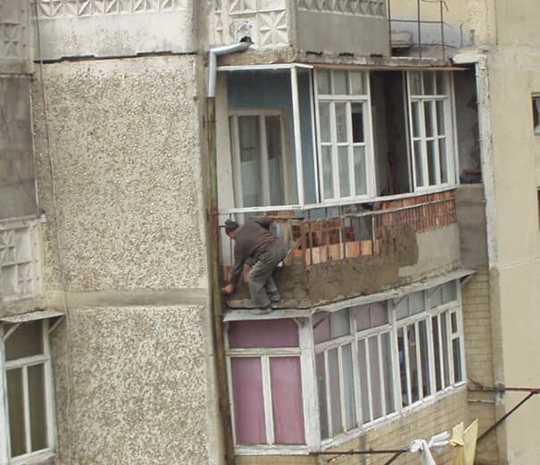 Un homme construit un balcon sans sécurité