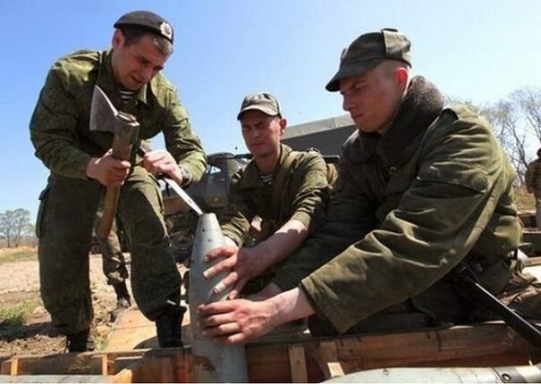 Des militaires qui tape sur une bombe avec une hache